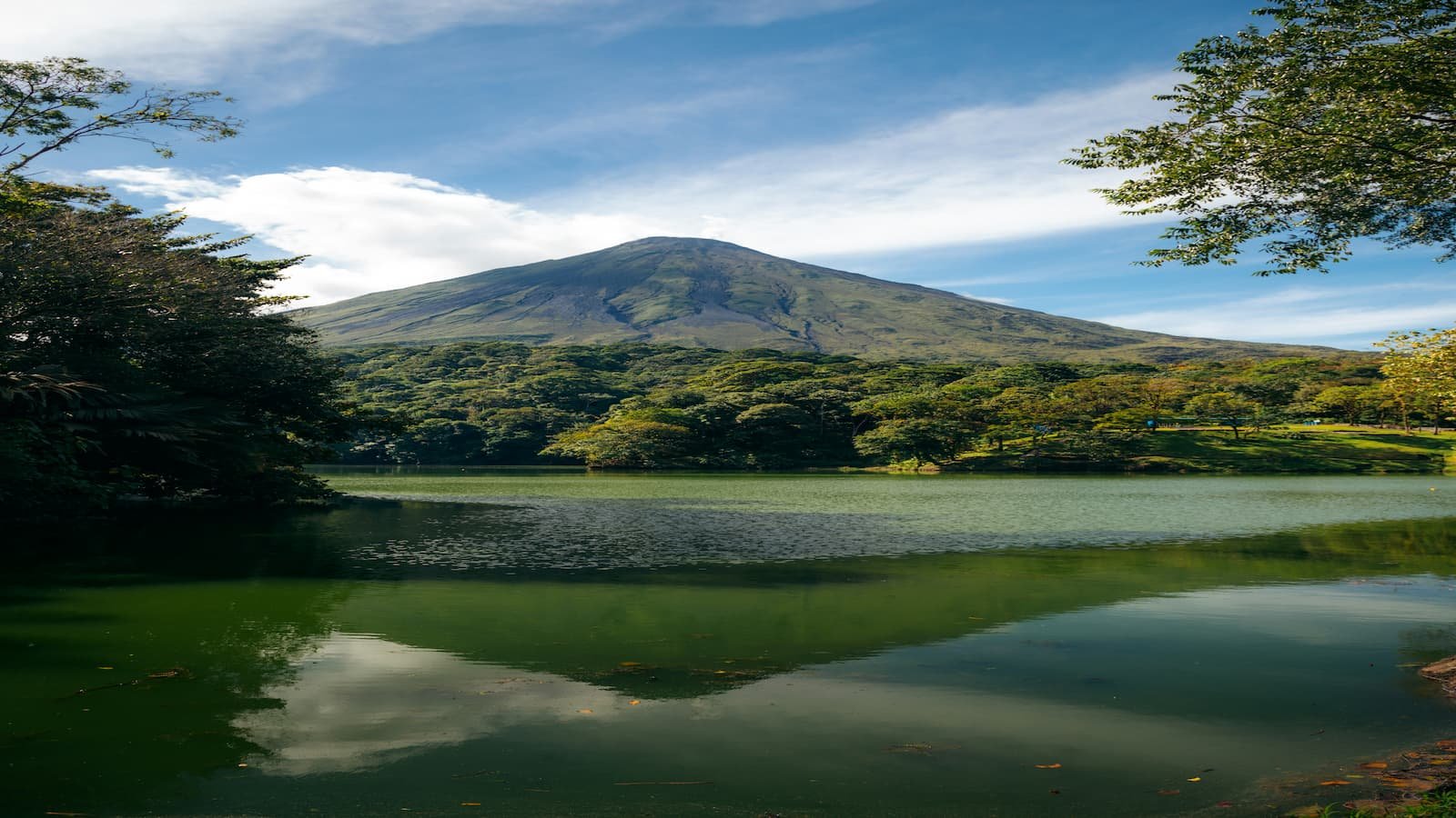 Volcán Arenal reflejado en el lago con selva tropical en Costa Rica
